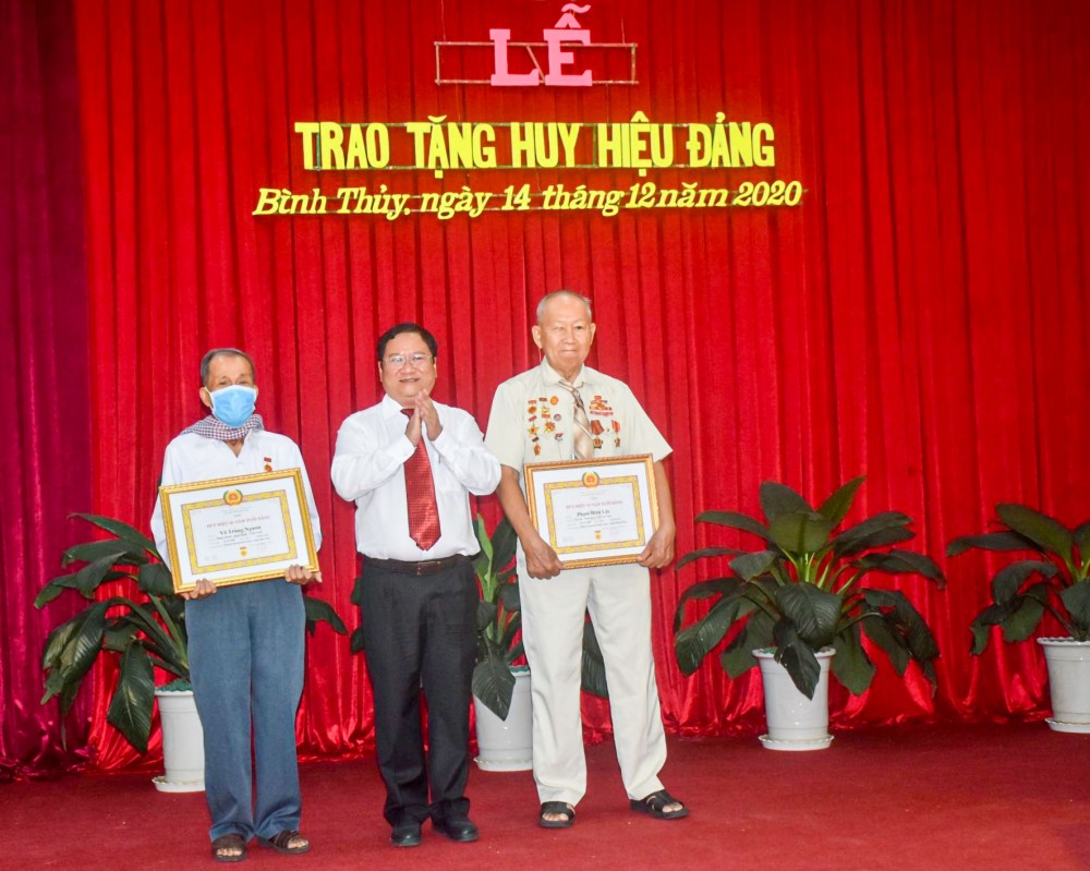Đồng chí Trần Quốc Vũ, Bí thư Quận ủy Bình Thủy, trao Huy hiệu 70 và 60 năm tuổi đảng cho đảng viên cao tuổi đảng.