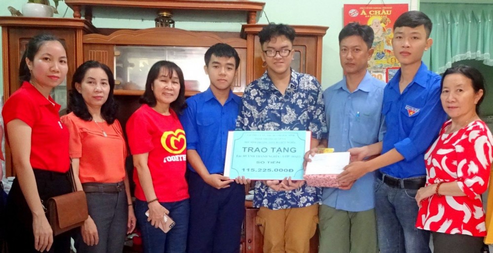 Các giáo viên và học sinh Trường THPT Bùi Hữu Nghĩa trao số tiền vận động được giúp em Huỳnh Thanh Nghĩa trị bệnh.