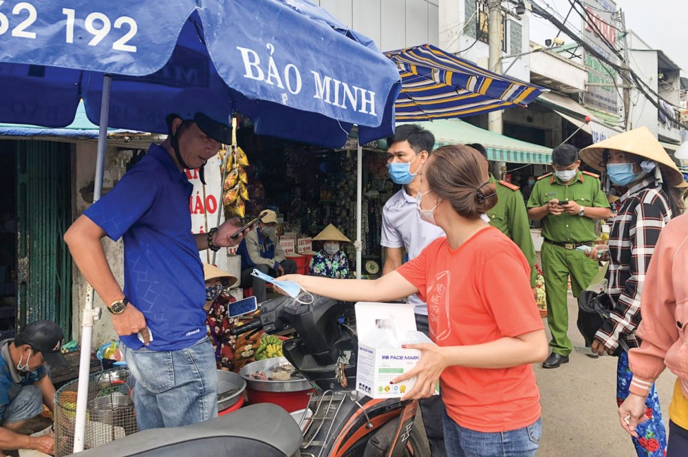 Phát khẩu trang cho người dân tại chợ Xuân Khánh. Ảnh: H.HOA