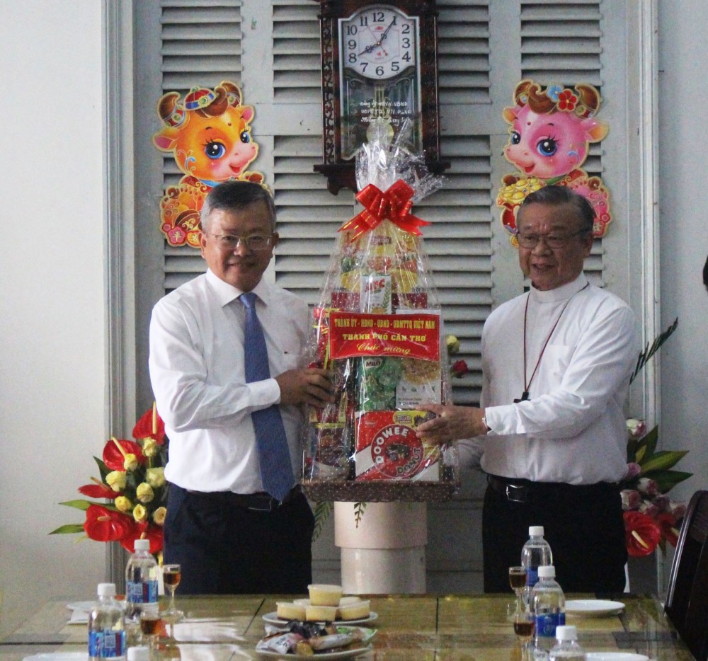 Đồng chí Nguyễn Trung Nhân (bên trái), Ủy viên Ban Thường vụ Thành ủy, Chủ tịch Ủy ban MTTQVN thành phố, tặng quà cho đại diện Tòa Giám mục Cần Thơ.