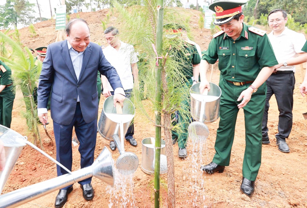 Chủ tịch nước Nguyễn Xuân Phúc cùng các đại biểu trồng cây tại Khu Di tích K9. Ảnh: THỐNG NHẤT - TTXVN