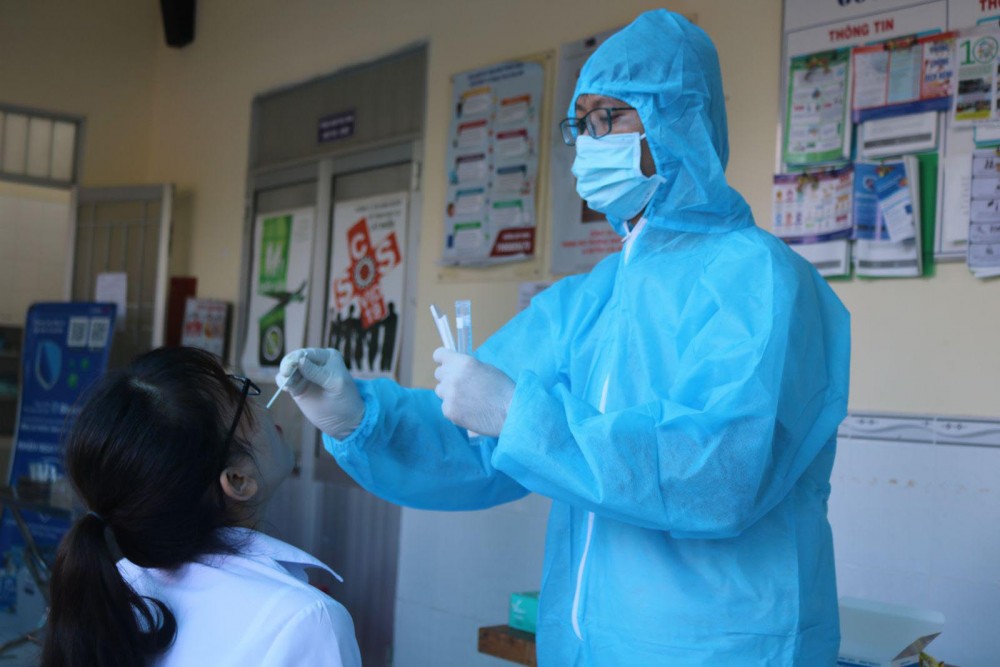 Nhân viên y tế lấy mẫu xét nghiệm SARS-CoV-2 cho thành viên một tổ bầu cử. Ảnh chụp tại Trạm Y tế phường An Khánh.