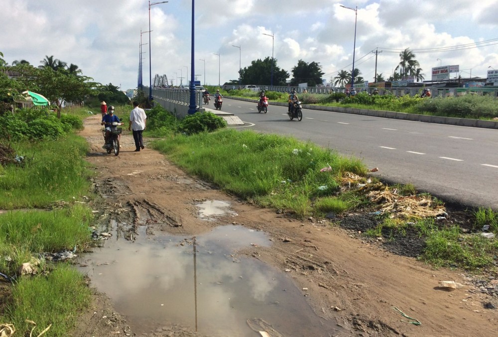 Tuyến đường dân sinh nhánh trái cầu Quang Trung chưa được nâng cấp, sửa chữa, người dân đi lại khó khăn.