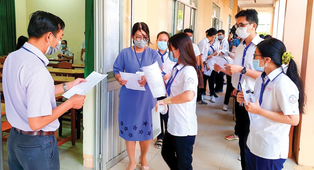 Cán bộ coi thi gọi tên thí sinh vào phòng thi, tại điểm thi Trường THPT Nguyễn Việt Hồng. Ảnh: B.NGỌC