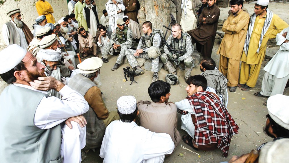 Binh sĩ Mỹ trò chuyện với người dân Afghanistan thông qua một thông dịch viên. Ảnh: AP