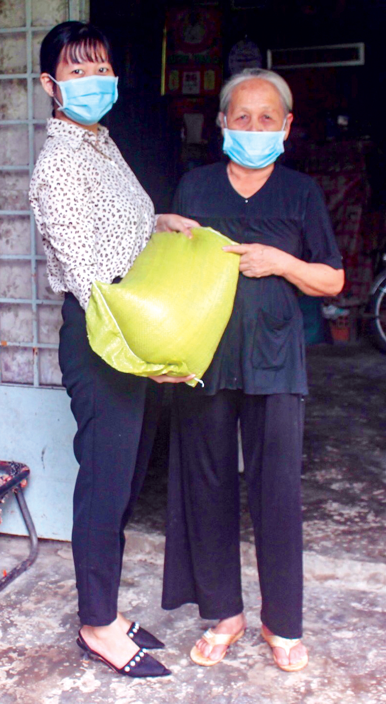 Anh Thư (bên trái) thăm hỏi, hỗ trợ gạo cho hội viên phụ nữ hoàn cảnh khó khăn.