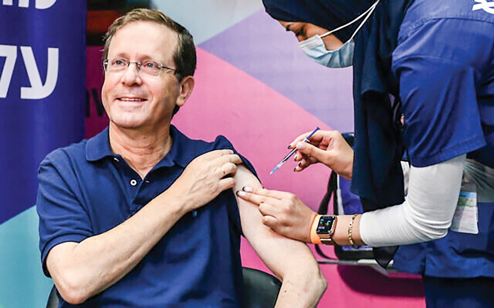Bao giờ thế giới đạt miễn dịch cộng đồng? Tổng thống Israel Isaac Herzog tiêm mũi vaccine thứ 3 hôm 30-7. Ảnh: GPO