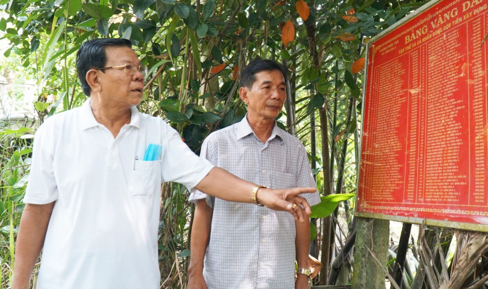 Nêu cao tinh thần tiên phong Ông Trần Quang Chánh, Bí thư Chi bộ, Trưởng khu vực Bình Hòa A, phường Phước Thới (bên trái) tích cực vận động người dân đóng góp xây dựng giao thông (ảnh chụp trong giai đoạn dịch COVID-19 chưa bùng phát và diễn biến phức tạp).