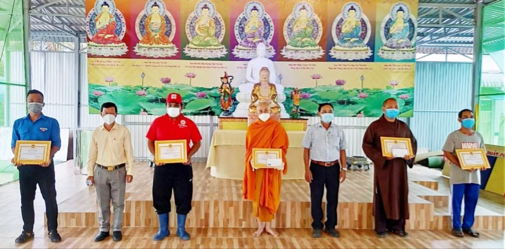 Anh Dai (bìa trái) được nhận giấy khen của chủ tịch UBND huyện.