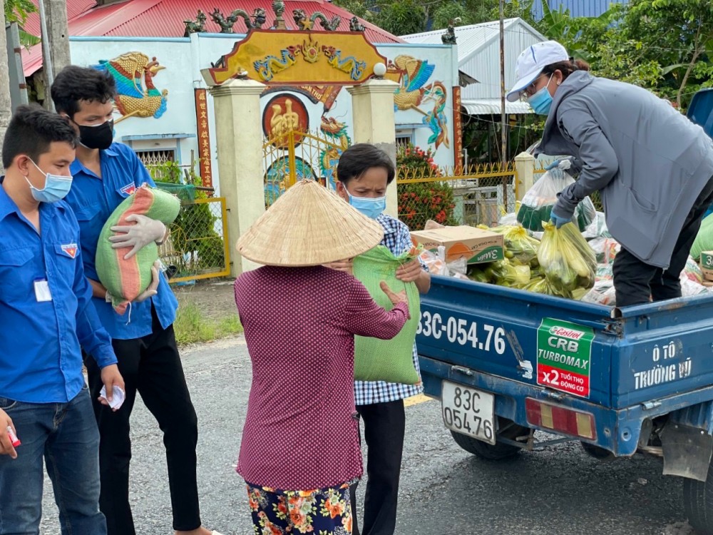 Cán bộ và đoàn viên thanh niên thị trấn Cờ Đỏ trao hỗ trợ nhu yếu phẩm cho người dân.