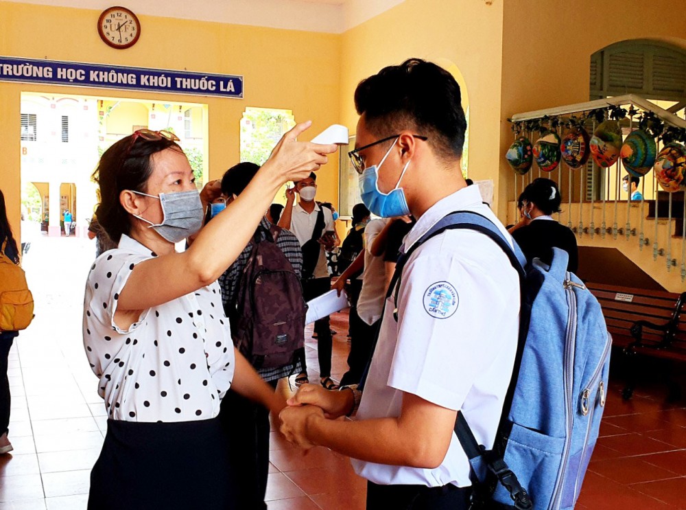 Học sinh Trường THPT Châu Văn Liêm được đo thân nhiệt trước khi vào lớp học.