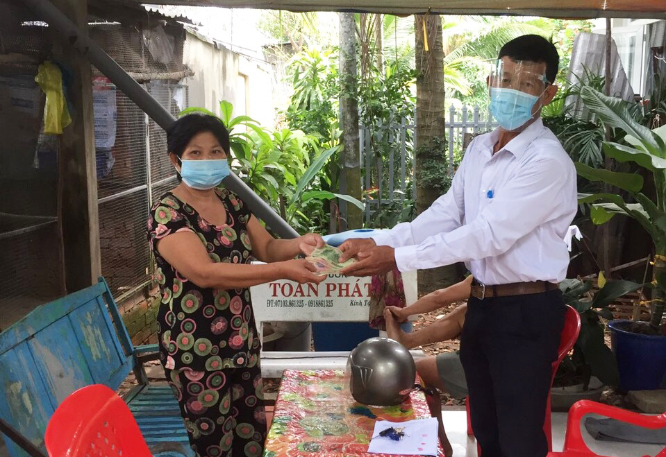 Đại diện lãnh đạo Ủy ban MTTQ quận Ô Môn trao tiền hỗ trợ cho người gặp khó khăn ở phường Châu Văn Liêm.