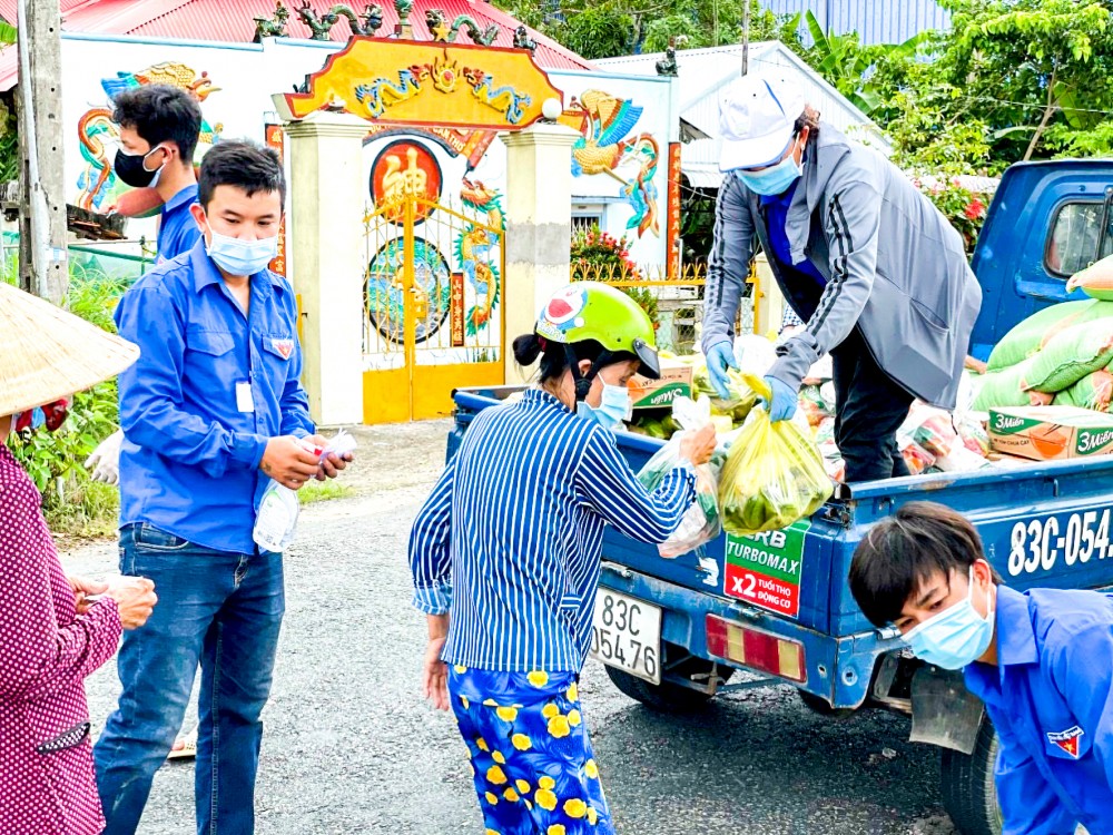 Cán bộ, công chức thị trấn Cờ Đỏ, huyện Cờ Đỏ cấp phát gạo và nhu yếu phẩm cho người dân.