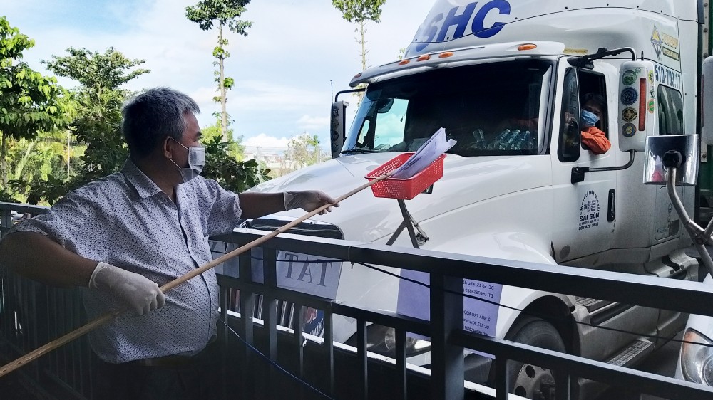 Lực lượng chức năng kiểm soát các giấy tờ cần thiết của một phương tiện trước khi lưu thông vào địa bàn TP Cần Thơ giao nhận hàng hóa.