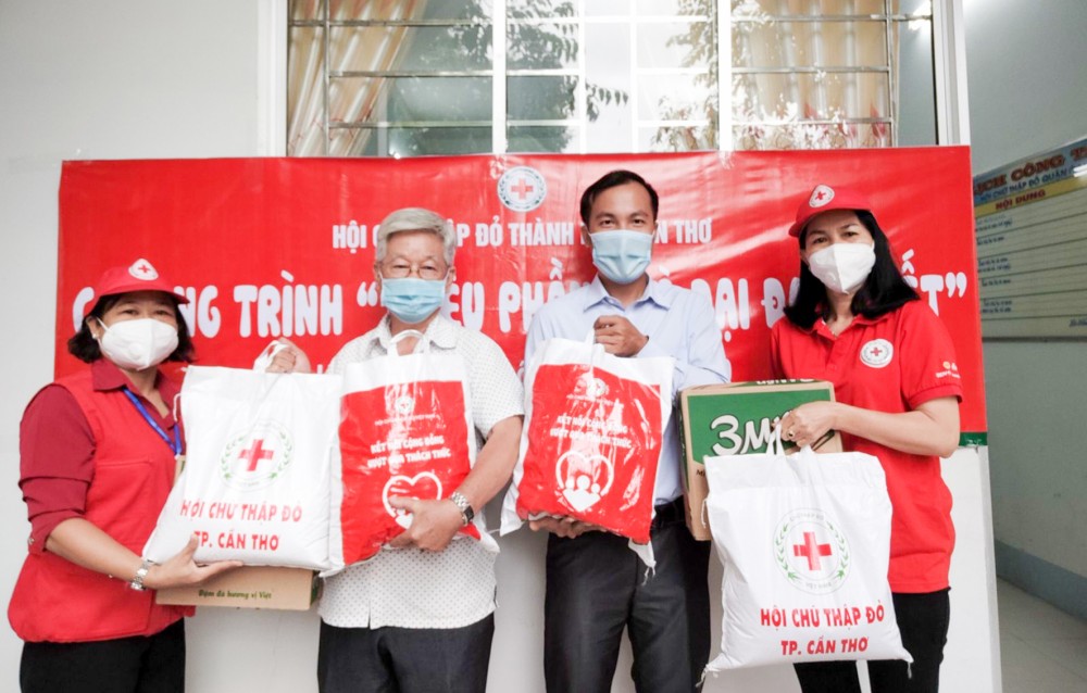 Bà Nguyễn Thị Ánh Nguyệt, Phó Chủ tịch Hội CTĐ TP Cần Thơ (bên phải) tặng “túi hàng gia đình CTĐ” cho lực lượng tình nguyện viên lái xe tham gia phòng, chống dịch ở quận Thốt Nốt. Ảnh: XUÂN ĐÀO