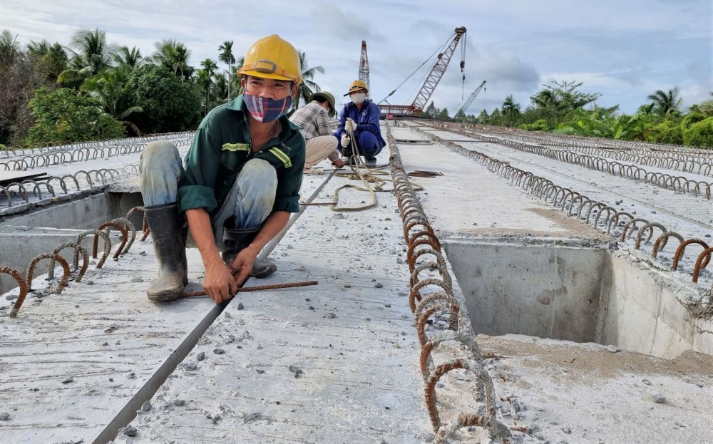 Công nhân thi công mặt cầu nhịp dẫn cầu Vàm Xáng.