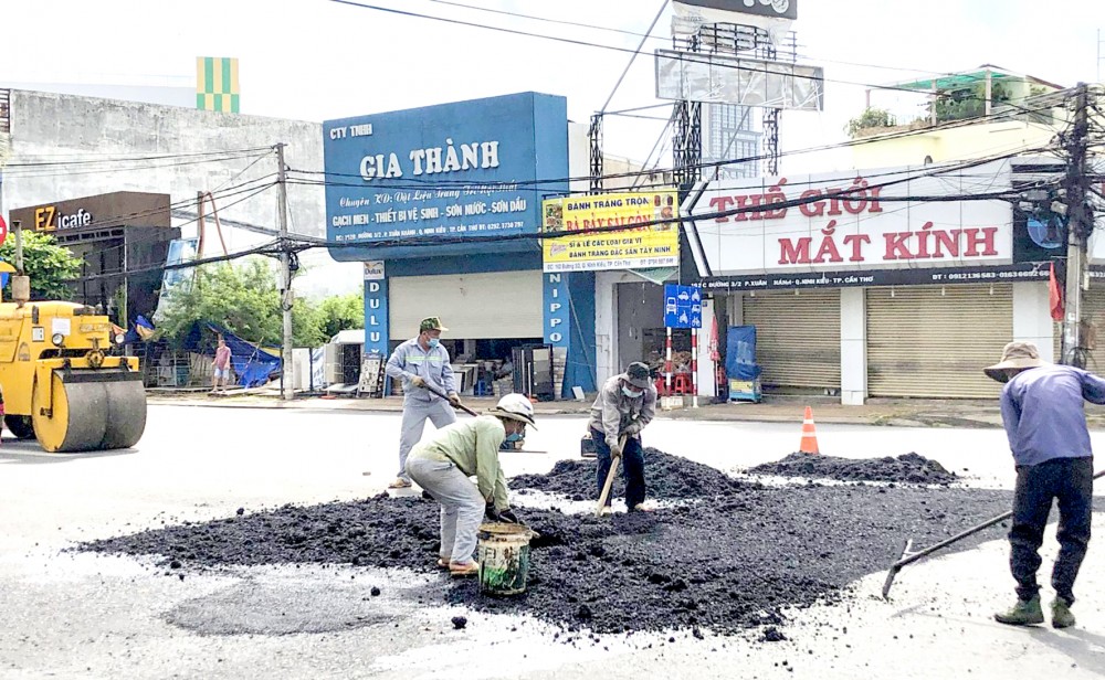 Công nhân đang giặm vá mặt đường hư hỏng tại giao lộ đường 3 Tháng 2 với đường Trần Ngọc Quế.