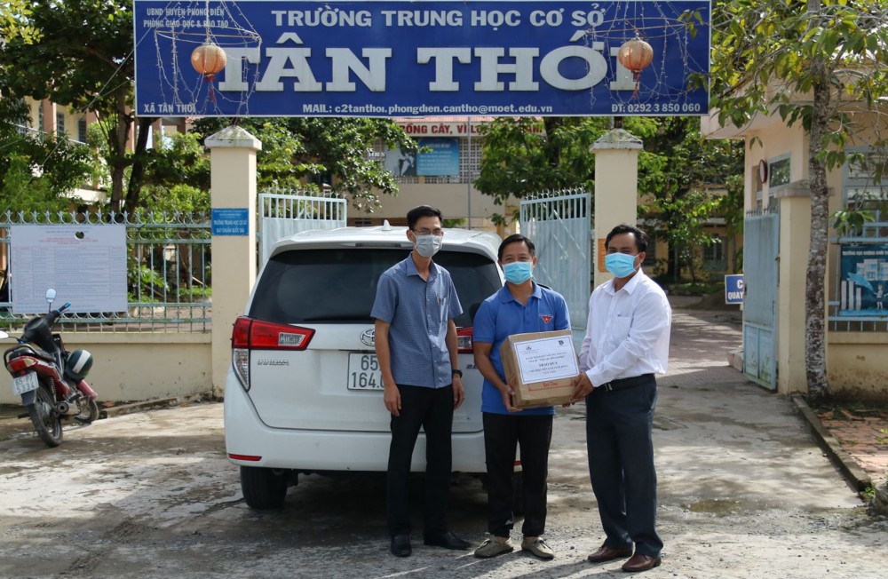 Đại diện Hành trình Kết nối yêu thương (thứ hai, từ trái qua) trao tập vở cho đại diện Trường THCS Tân Thới, xã Tân Thới, huyện Phong Điền để chuyển đến các học sinh có hoàn cảnh khó khăn.