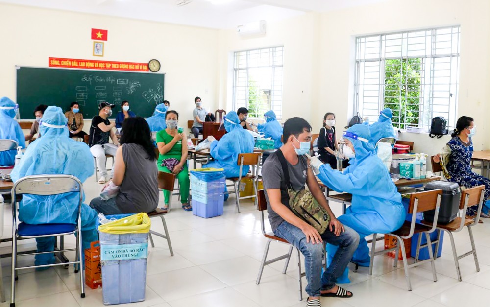 Cán bộ, nhân viên Bệnh viện Quốc tế Phương Châu tiêm vaccine cho người dân ở điểm tiêm Trường THCS An Khánh.