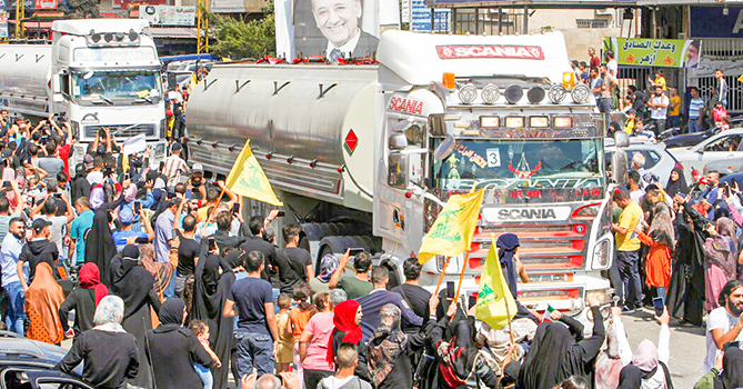 Đoàn xe chở dầu của Hezbollah trong vòng tay người ủng hộ. Ảnh: NYT