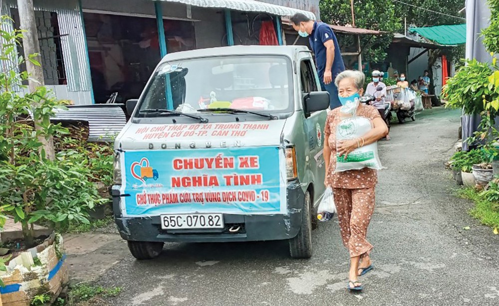 Người dân gặp khó khăn do dịch COVID-19 xã Trung Thạnh nhận phần quà hỗ trợ. Ảnh: CTV