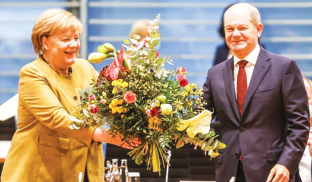 Bà Merkel nhận hoa từ ông Scholz trong cuộc họp nội các cuối cùng trên cương vị thủ tướng. Ảnh: Getty Images