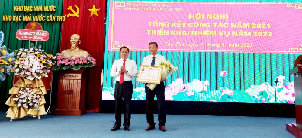 Thừa ủy quyền của Chủ tịch nước, Phó Chủ tịch UBND TP Cần Thơ Nguyễn Văn Hồng (bìa trái) trao tặng Huân chương Lao động hạng Ba cho ông Lê Minh Công, Phó Giám đốc KBNN Cần Thơ.