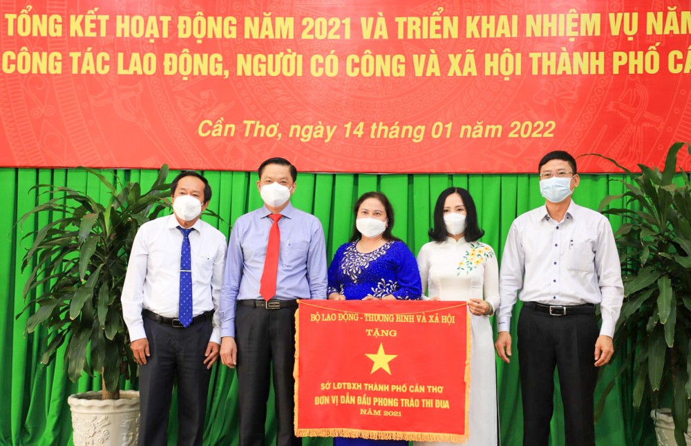 Đồng chí Dương Tấn Hiển, Phó Chủ tịch Thường trực UBND thành phố thừa ủy quyền Bộ trưởng Bộ LĐ-TB&XH, trao Cờ dẫn đầu thi đua năm 2021 cho Sở LĐ-TB&XH TP Cần Thơ.