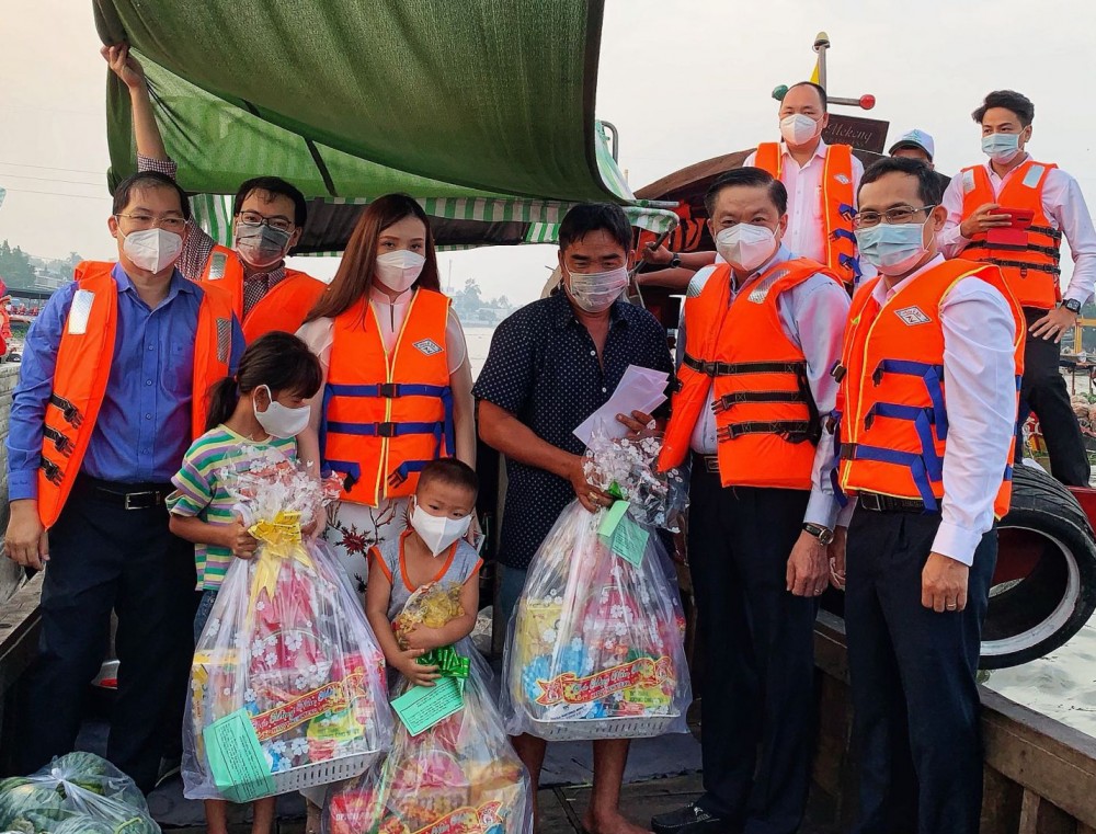 Đồng chí Dương Tấn Hiển (phải, từ thứ hai sang) thăm hỏi và trao quà cho người dân trên chợ nổi Cái Răng. Ảnh: Kiều Mai