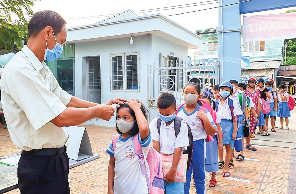 Trường Tiểu học Trần Hưng Đạo, quận Ô Môn, tổ chức kiểm tra, đo thân nhiệt cho học sinh khi đến trường (năm học 2020-2021). Ảnh: B.Ngọc