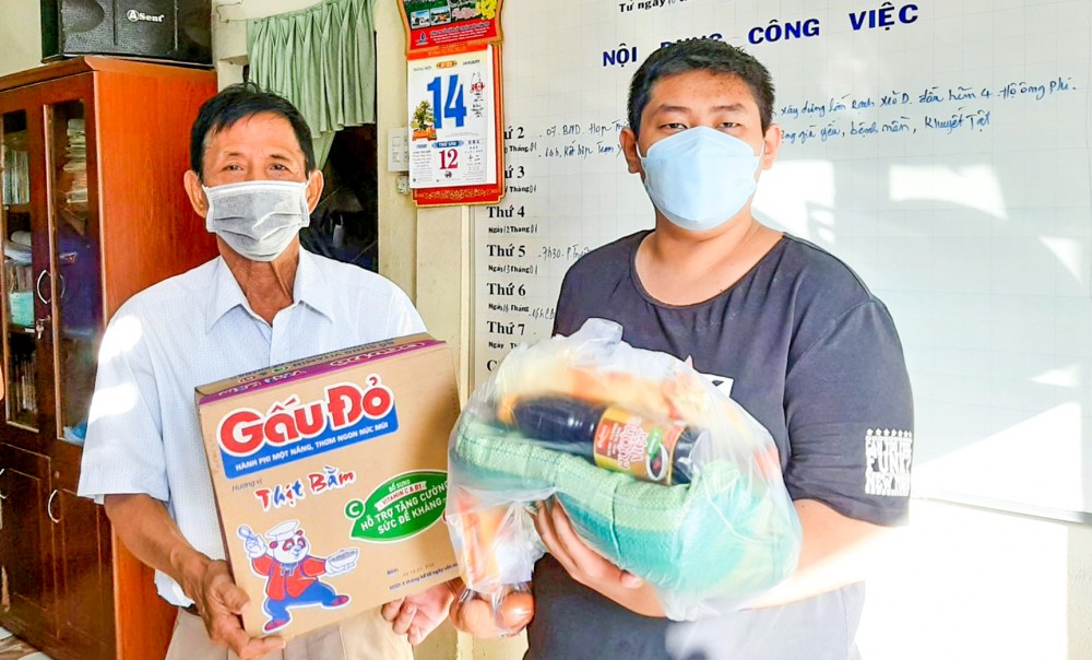 Ông Chiêm Văn Thường (bên trái) trao quà cho người dân.