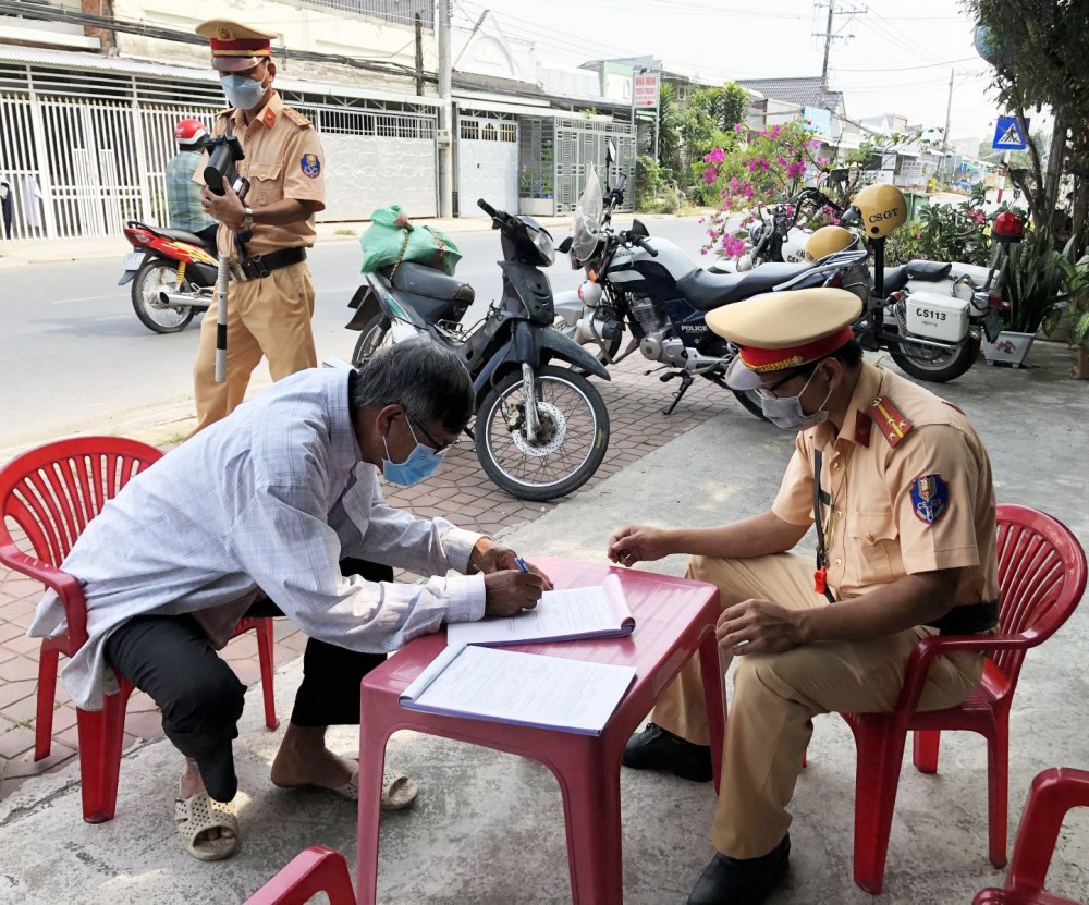 CSGT Công an huyện Vĩnh Thạnh hướng dẫn người vi phạm ký tên vào biên bản.