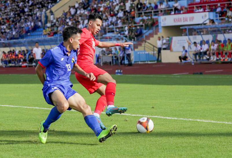 U23 Singapore (phải) thi đấu kiên cường trước U23 Lào ở ngày ra quân. Ảnh: Straits Times