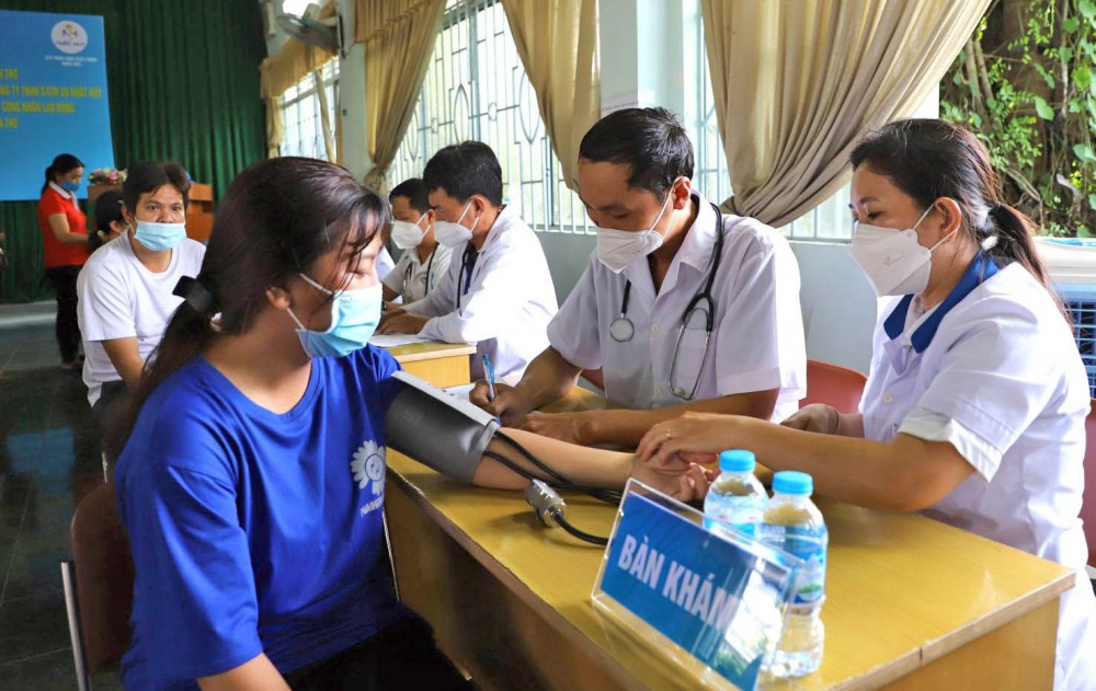 Các y, bác sĩ khám bệnh cho công nhân lao động.