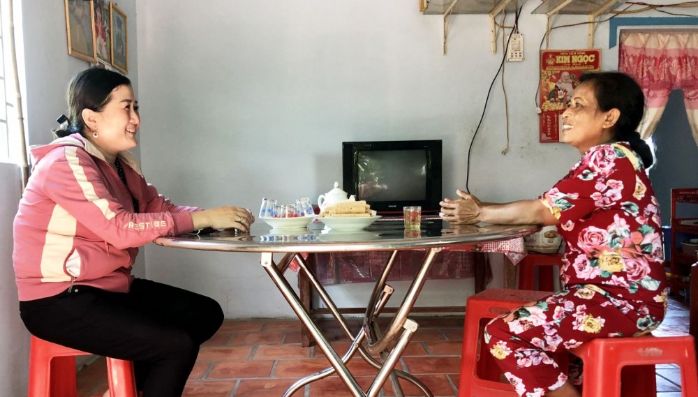 Cán bộ Mặt trận phường Trường Lạc (bên trái) thăm hỏi một hộ nghèo được tặng nhà Đại đoàn kết năm 2022 ổn định cuộc sống.