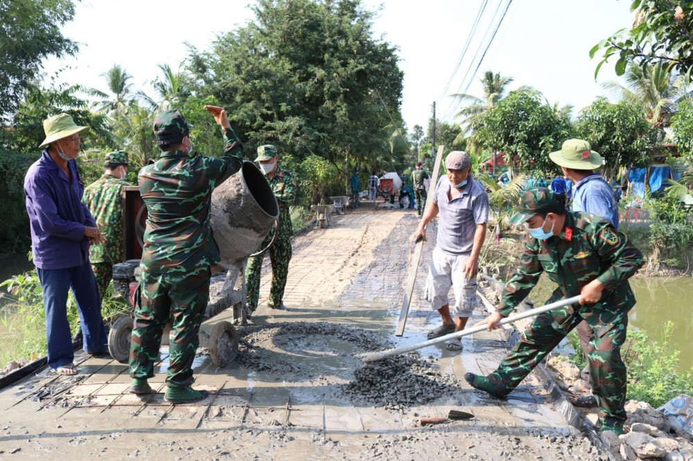 Cán bộ, chiến sĩ lực lượng vũ trang tham gia làm đường giao thông trong Tết Quân Dân năm 2022 ở xã Thạnh Quới, huyện Vĩnh Thạnh.