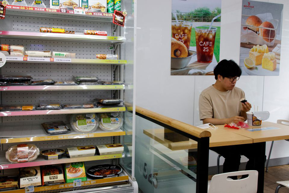 Một nhân viên văn phòng dùng bữa trưa trong cửa hàng tiện lợi tại Seoul hôm 24-6.