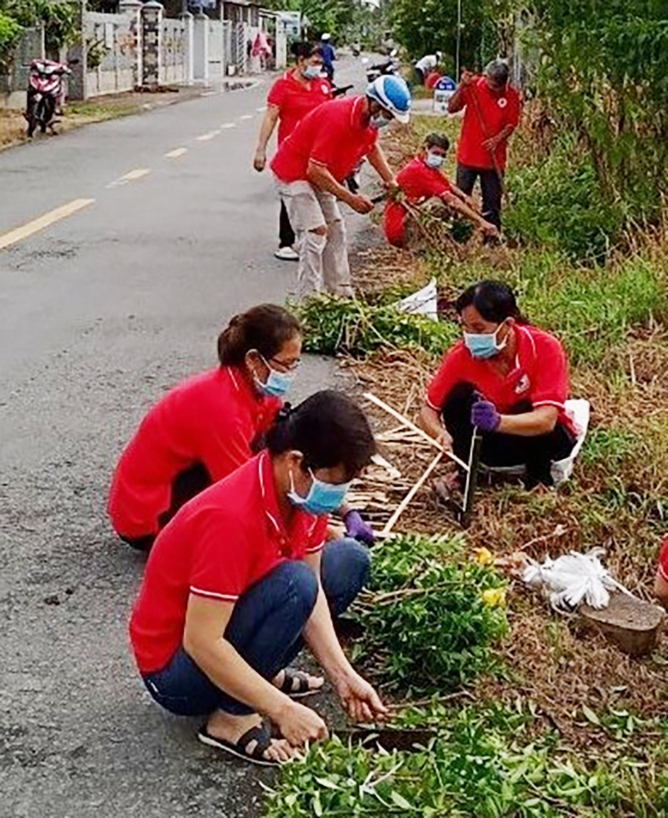 Cán bộ, tình nguyện viên Hội CTĐ phường Trường Lạc tham gia làm cỏ, phát quang tuyến lộ thông thoáng, đảm bảo giao thông an toàn. Ảnh: CTV