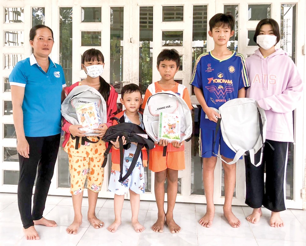 Cô Nguyễn Thị Tuyết Dung (bìa trái), trao quà cho con em hội viên phụ nữ dịp năm học mới 2022-2023.