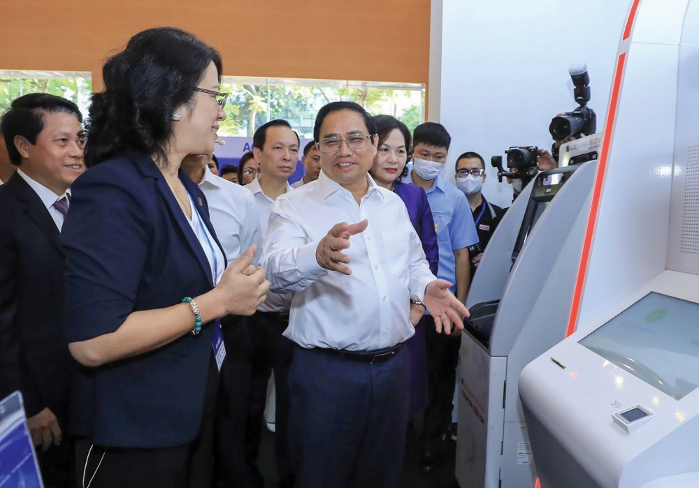 Thủ tướng Phạm Minh Chính cùng các đại biểu tham quan trưng bày công nghệ chuyển đổi số của một số ngân hàng. Ảnh: LÂM KHÁNH - TTXVN