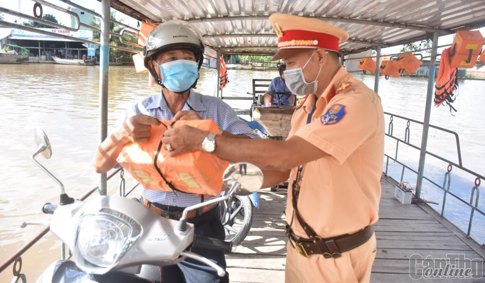CSGT-TT Công an huyện Phong Điền tuyên truyền, hướng dẫn người đi đò cách sử dụng dụng cụ nổi cứu sinh cầm tay.