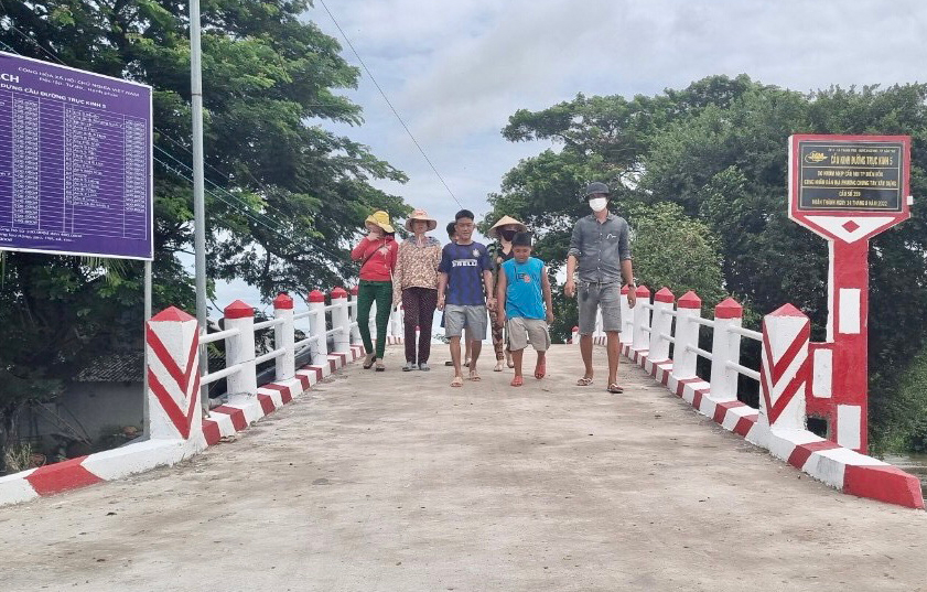 Đại diện Tổ Dân vận ấp 5 cùng người dân phấn khởi tham quan cầu qua đường trục kinh 5, ấp 5 vừa hoàn thành và đưa vào sử dụng. Ảnh: Tổ Dân vận ấp 5 cung cấp