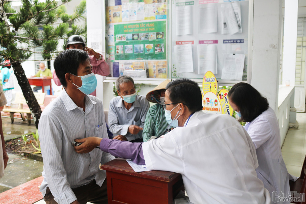 Nhân viên y tế khám cho người dân đến tiêm ngừa vaccine phòng COVID-19 tại xã Nhơn Ái, huyện Phong Điền.
