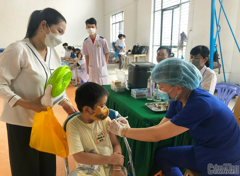 Nhân viên y tế tiêm vaccine phòng bại liệt cho trẻ tại điểm tiêm Trường Tiểu học Võ Trường Toản.
