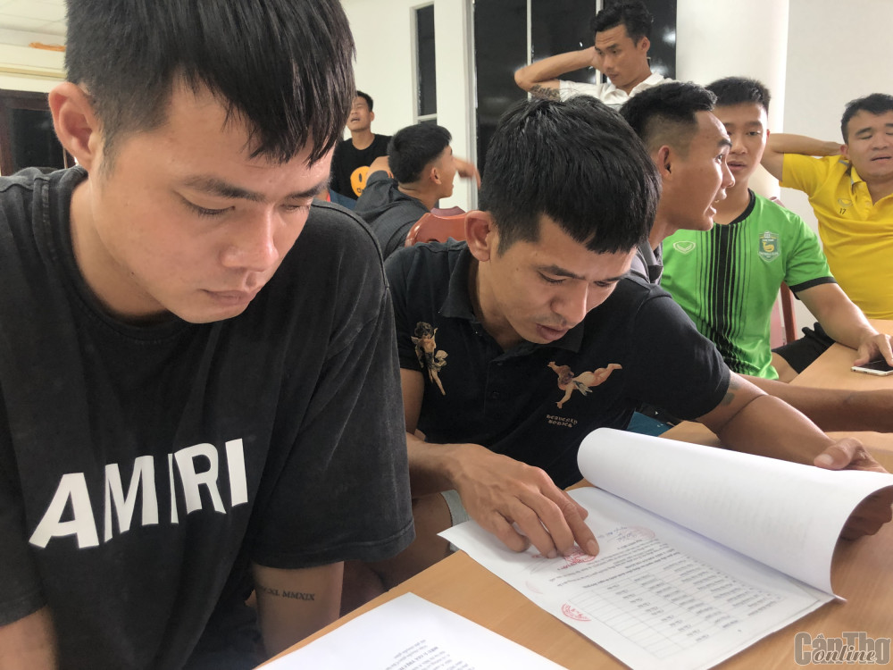 Các cầu thủ xem biên bản thỏa thuận với đơn vị chủ quản mới. Ảnh: Nguyễn Minh