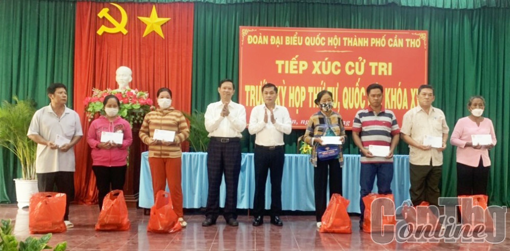 Lãnh đạo thành phố và quận Ô Môn trao quà tặng các hộ nghèo.
