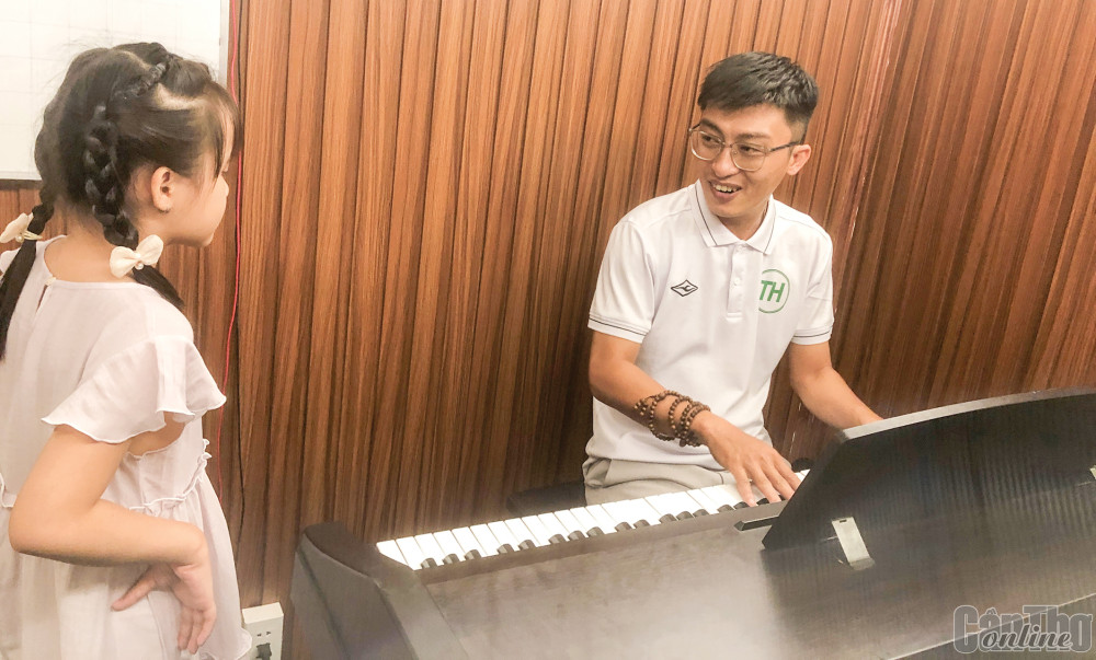 Nguyễn Phúc Hậu đang dạy thanh nhạc cho một thiếu nhi tại Trung tâm Âm nhạc TH Music.
