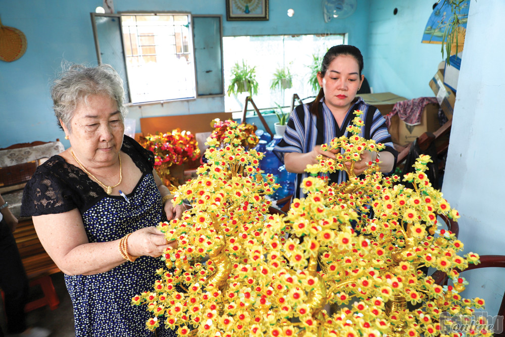 Chị Nguyễn Thị Thu Trang (bên phải) tất bật kết hoa để kịp giao cho khách hàng.