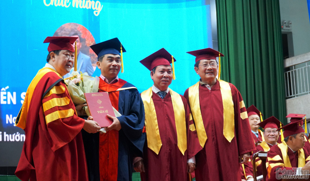 GS.TS Hà Thanh Toàn (bìa trái), Hiệu trưởng Trường ĐHCT trao bằng tiến sĩ cho tân khoa. Ảnh: B.NG