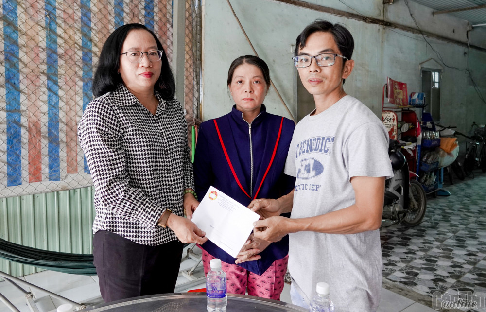 Bà Nguyễn Thúy Hằng (bên trái) trao tiền hỗ trợ cho vợ chồng anh Hùng và chị Trang.